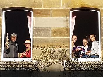 Thomas und Marion Reich musizieren im linken Fenster, die Töchter Rahel, Rut und Sara singen und musizieren im rechten Fenster des Pfarrhauses in Trieb. Foto: pr