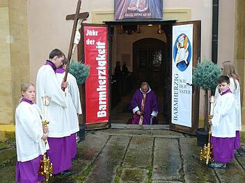Pater Adrian hat die "Pforte der Barmherzigkeit" am Südportal der Wallfahrtsbasilika Marienweiher geöffnet und spricht kniend ein Gebet. Fotos: kpw