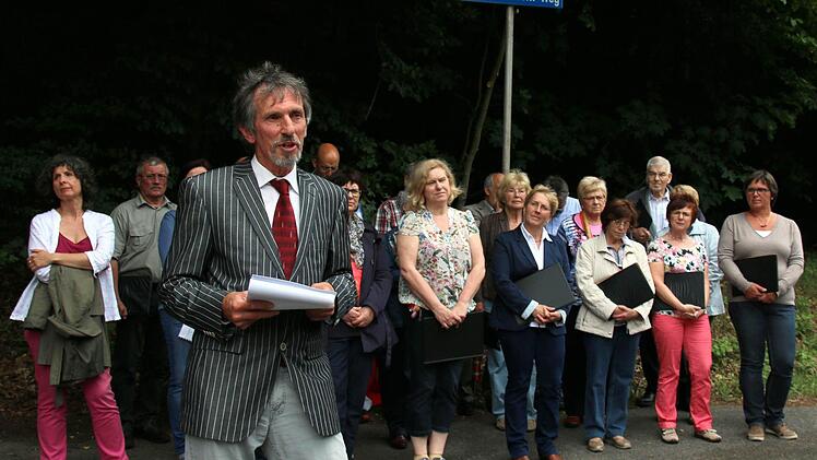 Mit der Benennung eines Weges im Pfarrschrot ehrte die Gemeinde Niederfüllbach am Samstag ihren verstorbenen Ehrenbürger Franz Möckl. Selten habe eine Ehrung so gut gepasst, meinte Bürgermeister Martin Rauscher (vorn). Die Einweihung wurde untermalt von Liedern des Komponisten, vorgetragen vom Singverein Niederfüllbach (Leitung Carolin Heckel, links), den Möckl viele Jahre geleitet hatte. Foto: Bettina Knauth