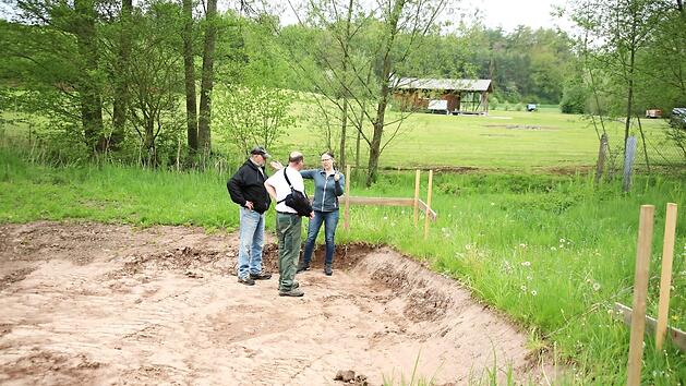 Hier, wo bereits die Erde ausgehoben wurde, sollen einmal die zusätzlichen Container mit sanitären Anlagen stehen. Martina Kilian zeigt Andreas Ehrhard und Bernhard Bäck die Höhen an.  Fotos: Bettina Knauth