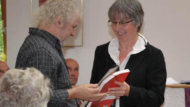 Pfarrerin Reichel überreicht dem Künstler Werner Tögel ein Präsent.