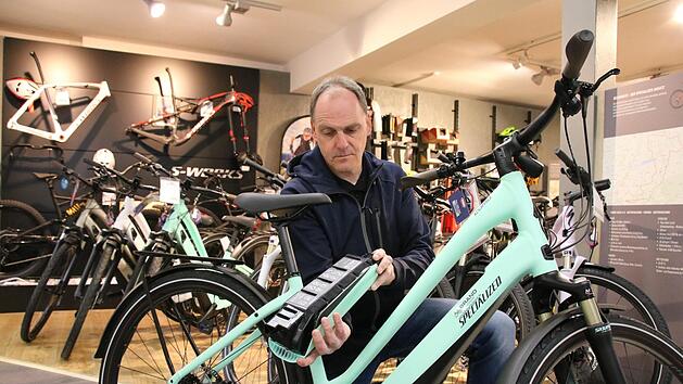 Stefan Brand von der Bikeworld Brand in Euerdorf zeigt den Akku eines E-Bikes: Mittlerweile sind die Akkus immer unauff&auml;lliger im Rahmen verbaut. Foto: Ralf Ruppert