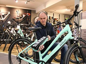 Stefan Brand von der Bikeworld Brand in Euerdorf zeigt den Akku eines E-Bikes: Mittlerweile sind die Akkus immer unauffälliger im Rahmen verbaut. Foto: Ralf Ruppert