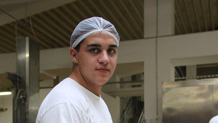 Azubi Enrico Müller belegt Käsebrötchen.