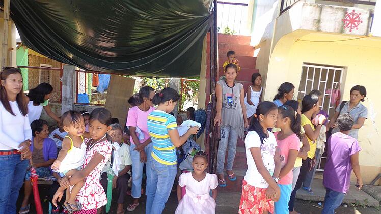 Auf dem Dorfplatz haben sich die Frauen und Kinder der Dorfgemeinschaft versammelt