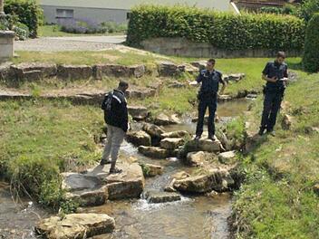 Wieder angezogen, erklären Polizeibeamte dem Nacktbader zu Naisa, dass    dies nicht  üblich ist und es zum öffentlichen Baden Badekleidung braucht. Foto: Joseph Beck
