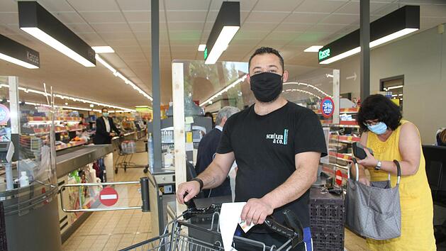 Ahmad Kara Ballali zückt beim Einkauf nach der Arbeit ganz selbstverständlich die Karte: er ist einer derjenigen, der am liebsten mit der Bankkarte bezahlt, weil es praktisch und ungefährlich ist. Foto: Sonny Adam