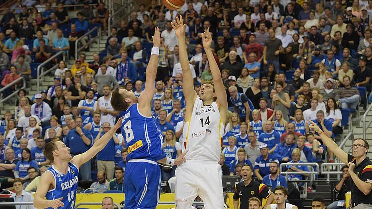 Dirk Nowitzki wirft über die Isländer Hlynur Baeringsson. Logi Gunnarsson (links) beobachte die Szene. Foto: Rainer Jensen/dpa