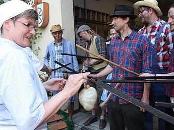 Tanja Sagner hängt einen dicken Presssack an die Stecken der Willmersreuther "Woschdfohrer". Auf die Trage wurde bereits ein großer Topf mit Wurstbrühe gestellt. So ist es Brauch bei der "Krumba". Fotos: Sonny Adam