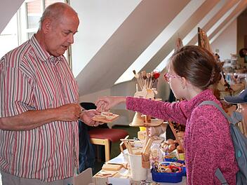 Josef Schottmüller (links) zeigt gerne seine Werke, erklärt und lässt die Kinder ausprobieren, was er da geschaffen hat. Foto: Katharina Becht