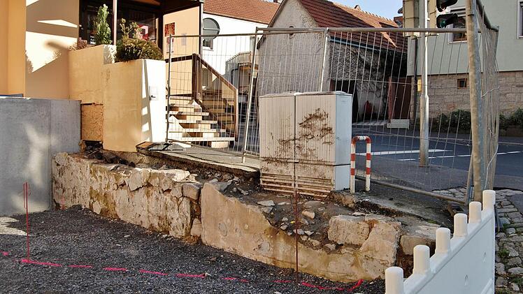 Im schrägen Winkel zum Straßenfundament soll die Eingangsfläche vor der Apotheke aufgefüllt und entlang der roten Linie von einer Betonmauer mit Geländer eingefasst werden. Foto: Sigismund von Dobschütz