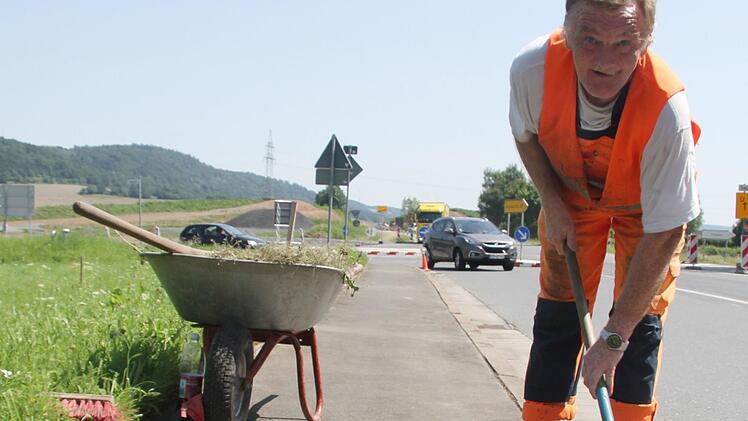 Am Straßenrand, gleich beim Untersteinacher Kreisel kratzt Siegfried Knarr (57) vom Bauhof Untersteinach Unkraut aus den Fugen zwischen Gehweg und Straße. Auch Knarr hat ein Utensil dabei, das für ihn jetzt überlebenswichtig ist: eine 1,5 Liter-Flasche mit Getränk.  Foto: Sonny Adam