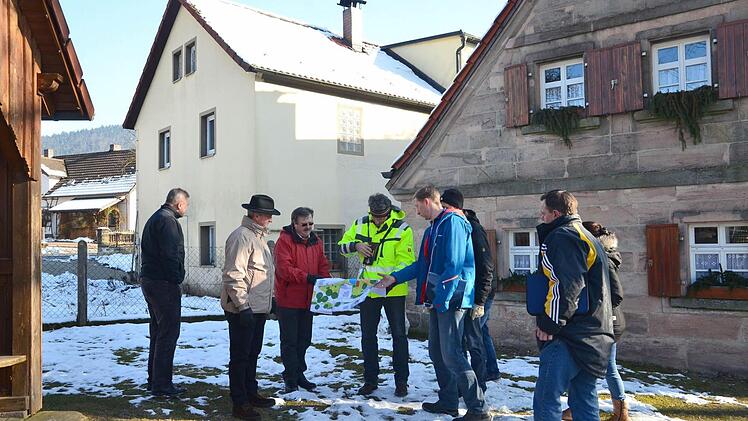 Siegfried Käb-Bornkessel vom Amt für Ländliche Entwicklung (gelbe Jacke) informiert die Vorstandsmitglieder der Teilnehmergemeinschaft Lindau II über die Möglichkeiten der Nutzung des Grundstücks Hastreiter (links, rechts das Dorfhaus).