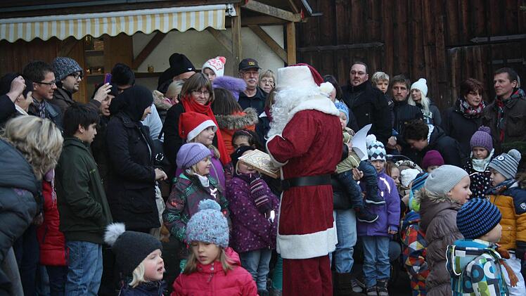 Der Weihnachtsmann befragt die Kinder, ob sie brav waren oder ob sie ihm vielleicht ein Gedicht aufsagen können. Im Hintergrund Pfr. Weichert, wie sie einigen der neuen Flüchtlinge die rede des Weihnachtsmann ins Englische übersetzt. Foto: Joachim WeichertDer Weihnachtsmann befragt die Kinder, ob sie brav waren oder ob sie ihm vielleicht ein Gedicht aufsagen können. Im Hintergrund Pfr. Weichert, wie sie einigen der neuen Flüchtlinge die rede des Weihnachtsmann ins Englische übersetzt. Foto: J...