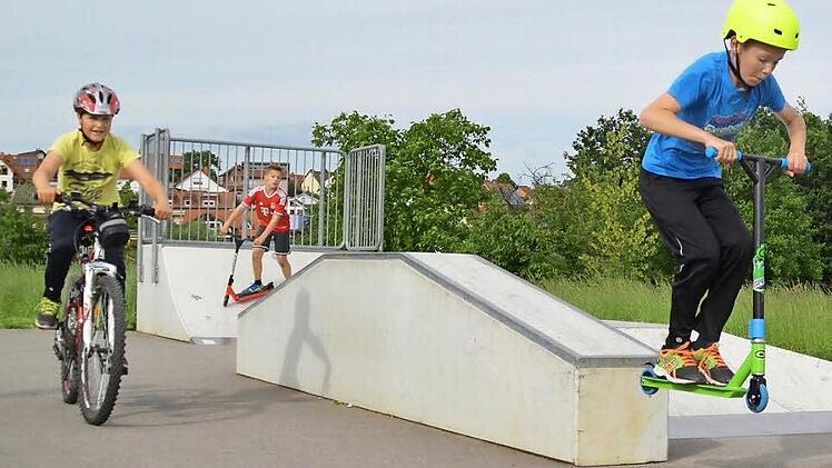 Der "Multi" in Wollbach ist auch mit Skater-Elementen ausgestattet. Marcel (von rechts) und Ramon befahren diese gerne mit ihren Rollern, während Luis auf dem Fahrrad zuschaut. Foto: Kathrin Kupka-Hahn
