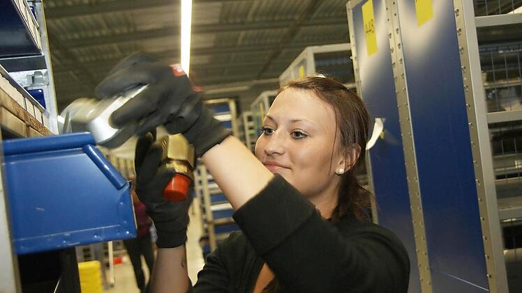 Auszubildende Katharina Hill hilft die Regale in der neuen Lagerhalle einzuräumen.