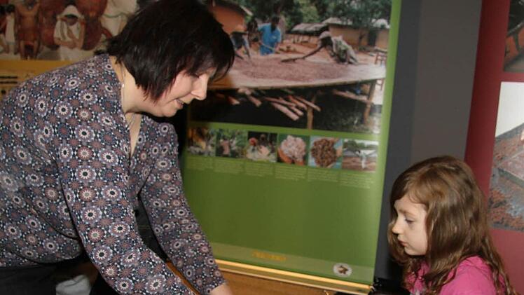 Uschi Prawitz, Leiterin der Mupäz-Juniorakademie, zeigt Maya Hermann, wie man Kakaosplitter richtig zerkleinert. Das Pulver schmeckt allerdings noch nicht süß. Fotos: Sonja Adam