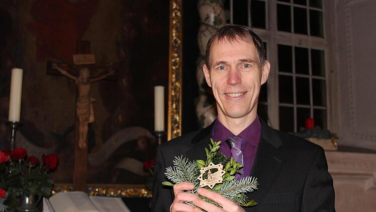 Pfarrer Ronald Henke präsentiert stolz den Holzstern mit dem Motiv der Schlosskirche Hassenberg, der auch noch nach der Veranstaltung erhältlich sein wird. Foto: Cindy Dötschel