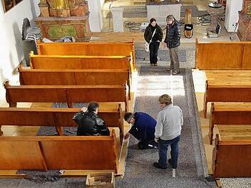 Wiedereinbau der ersten Bankreihen nach der Aufarbeitung durch Restauratorin Anja Fuchs (hinten mit Architekt Georg Schilling). In der Bank sitzend Pfarrer P. Kosma Rejmer, kniend Pfarrgemeinderatsvorsitzender Michael Gärtlein und Kirchenpfleger Karlheinz Kohles. Fotos: Ingrid Kohles
