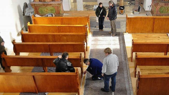 Wiedereinbau der ersten Bankreihen nach der Aufarbeitung durch Restauratorin Anja Fuchs (hinten mit Architekt Georg Schilling). In der Bank sitzend Pfarrer P. Kosma Rejmer, kniend Pfarrgemeinderatsvorsitzender Michael Gärtlein und Kirchenpfleger Karlheinz Kohles. Fotos: Ingrid Kohles