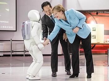 Kanzlerin trifft Roboter: Mit dem Händeschütteln klappt es aber noch nicht.  Foto: Michael Kappeler, dpa