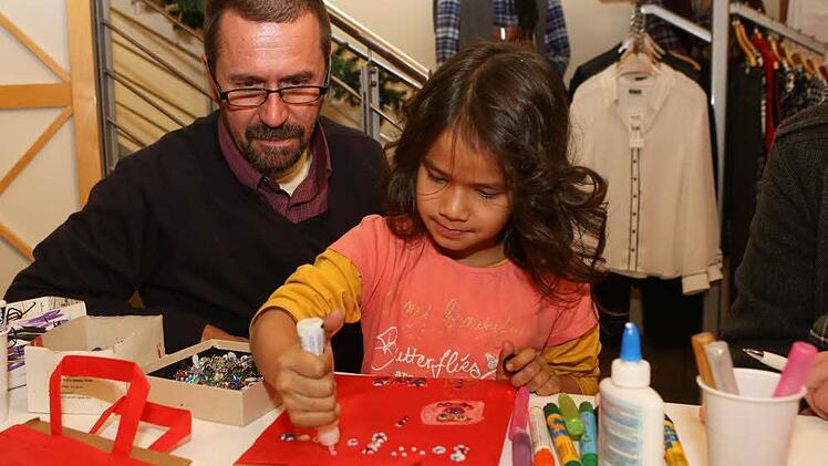 Mit Papa Thomas gestaltet Sominah Frank eine Tasche im Modehaus Schick. Foto: Barbara Herbst