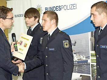 Thomas Lehmann, Leiter des Ausbildungszentrums Oerlenbach, überreicht die Urkunden an die drei besten Absolventen (von rechts) Benjamin Berger, Tobias Wengenmayer und Florian Schüßler.  Foto: Stefan Geiger