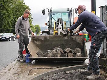 Michael Schuhmann (rechts) und Polier Gerhard Schäfer verladen Pflastersteine in der Bahnhofstraße, Bad Brückenau. Foto: Ulrike Müller