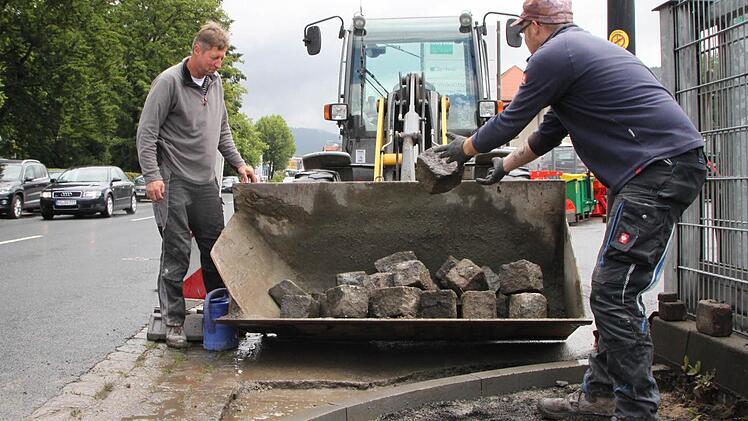 Michael Schuhmann (rechts) und Polier Gerhard Schäfer verladen Pflastersteine in der Bahnhofstraße, Bad Brückenau. Foto: Ulrike Müller
