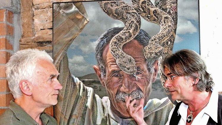 Peter Wolf (rechts) stellt in der Marienanstalt Fotos aus. Sehr beeindruckend ist sein Bild "Schlangenflüsterer". Hartmut Hessel stellte den Fotografen, der eigentlich Statiker ist, vor.  Foto: Dieter Britz