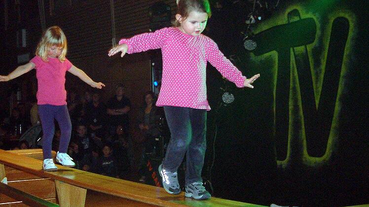 Da gehört Mut dazu, und den hat   der Nachwuchs in Sand: Traumsicher balancieren die  drei- bis vierjährigen Mädchen  über die Bank.