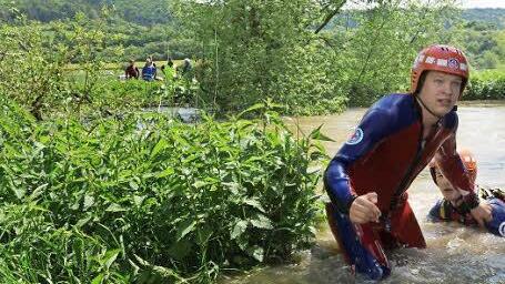 Mitglieder der Wasserwacht steigen aus dem Fluss.