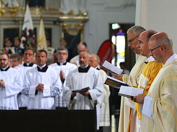 Der neue W&uuml;rzburger Bischof Franz Jung (Mitte, goldenes Gewand) steht mit kirchlichen W&uuml;rdentr&auml;gern im Dom vor dem Altar. Foto: Karl-Josef Hildenbrand/dpa