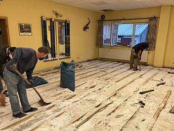 Weil der Holz-Fußboden im Musikerheim bis auf die Betonplatte durchnässt war, entfernten ihn freiwillige Helfer. Foto: René Gerner