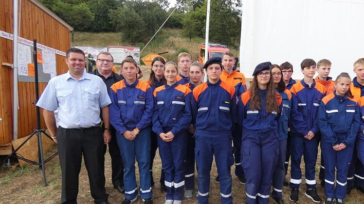 Kreisjugendwart Johannes Krines und Kreisbrandinspektor Peter Pfaff (von links) zusammen mit den Teilnehmern der Jugendfeuerwehren aus Hofheim, Unterpreppach, Prappach, Zeil, Ziegelanger und Trossenfurt/Tretzendorf/Hummelmarter, die mit Stufe&nbsp;3 die h&ouml;chste Auszeichnung der "Jugendflamme" verliehen bekamen. Foto: Christian Licha