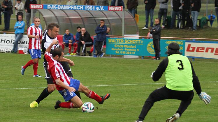 Im letzten Moment blockt hier der Dampfacher Julien Ziegler den Schuss des Sander Thorsten Schlereth ab, rechts DJK-Torwart Edwin Stierl und links Veton Munisi.