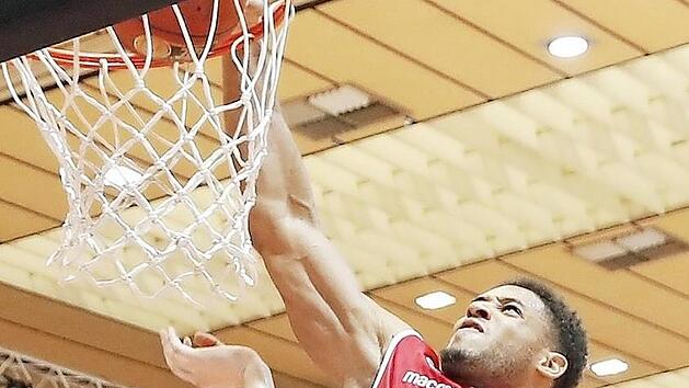 Kraftvoll schlie&szlig;t Augustine Rubit (rotes Trikot) gegen Robin Benzing per Dunking ab, &auml;rgerte sich am Ende aber ma&szlig;los &uuml;ber die Niederlage in W&uuml;rzburg. Foto: Daniel L&ouml;b