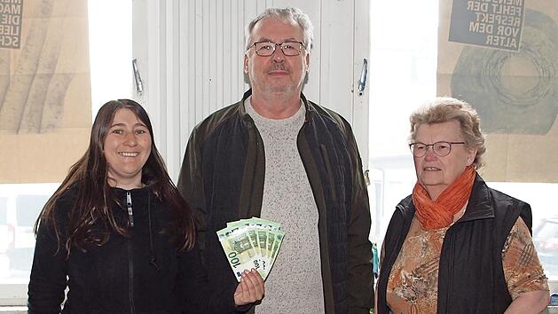 Daniela Fehn (li.), die Projektleiterin der Lichtenfelser Tafel, und die ehrenamtliche Helferin Brigitte K&ouml;rner dankten Werner M&auml;usbacher, Abteilungsleiter der Theatergruppe Buch am Forst, f&uuml;r die Spende von 500 Euro zugunsten der Tafel.