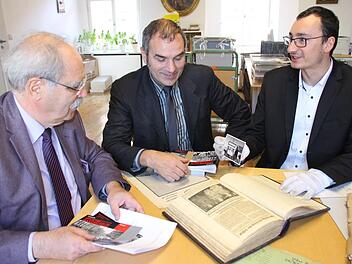 Professor Gert Melville, VHS-Leiter Rainer Maier und der Leiter des Coburger Staatsarchivs, Alexander Wolz, sichten einige der Archivalien aus der NS-Zeit, unter anderem das Tagebuch der NSDAP-Kreisleitung aus dem Jahr 1941/42. Foto: Simone Bastian