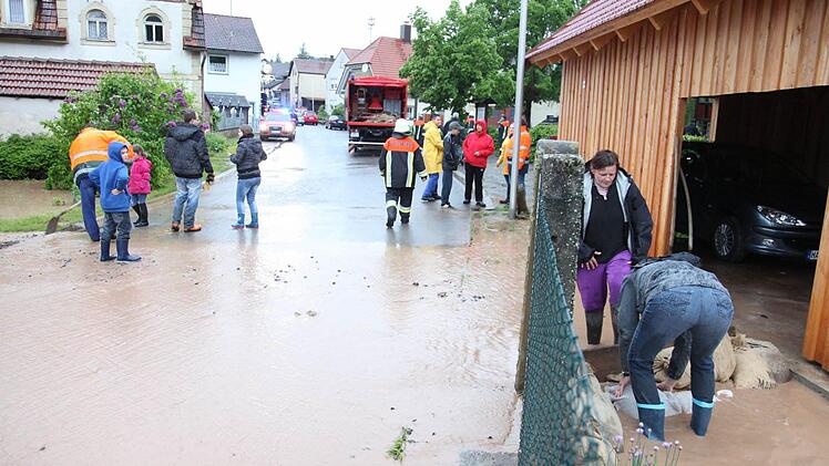 Der Krumbach in Krum führte meterhoch Wasser. Es schwappte in Gartenanlagen und überflutete mehrere Straßen und Wege. An der Brücke in der Ortsmitte staute sich Unrat, das Wasser stand bis zur Oberkante. Anwohner bauen Sandsäcke auf und schippen Höfe und Garagen leer.