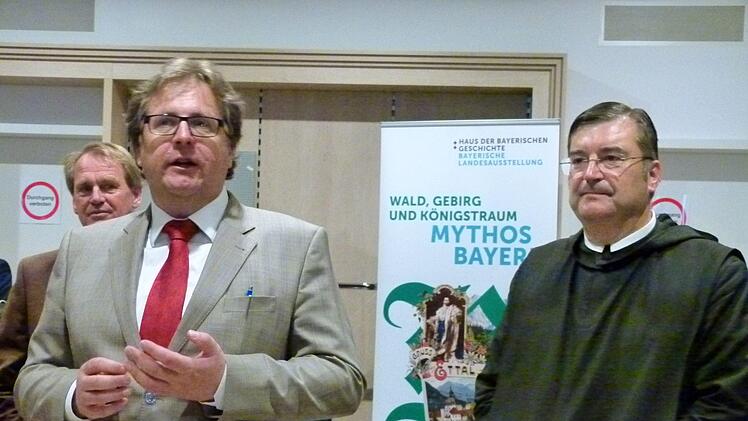 Direktor Richard Loibl (links) und Pater Johannes Bauer vor dem Ausstellungsplakat.