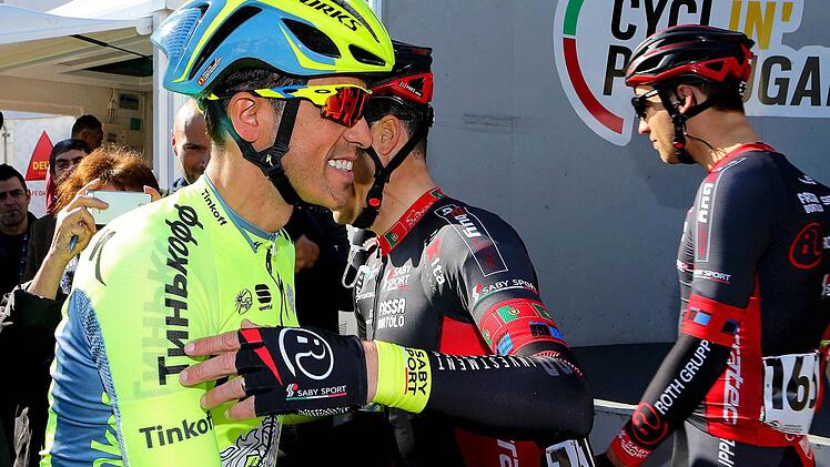 Alberto Contador (links) stand vor dem Start der Algarve-Rundfahrt am Mittwoch, 17. Februar, im Mittelpunkt. Hier begrüßt der Spanier seinen Landsmann vom Schweizer Team Roth David Belda Garcia. Rechts im Hintergrund der Altenkunstadter Grischa Janorschke.  Foto: Luis Forra/dpa