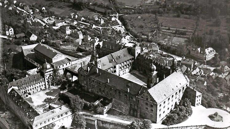 Luftbild der Plassenburg aus dem Jahr 1933. Vor dem Westflügel der Hochburg ist der Verwaltungsbau zu erkennen, im Osten hinter der Burg das Zellengefängnis. Zu sehen ist auch der "Holz- oder Kirchengang" über den Kasernenhof.
