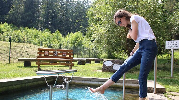 Abkühlung pur! Franziska Sittig taucht die Füße ins zehn Grad kalte Quellwasser im Ebersbacher Kneippbecken. Foto: Jochen Nützel