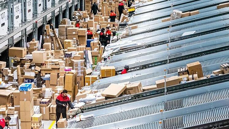 Mitarbeiter eines Paketdienstes sortieren Sendungen in einem Paketsortierzentrum. Die Zustellung sorgt manchmal auch für Ärger. Foto: Rob Engelaar, dpa