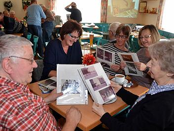 In alten Photoalben schmökern - ehemalige Sportler, Trainer und Kampfrichter des Turngaues Rhön/Saale kamen in Arnshausen zum "Generationentreffen" zusammen. Die Resonanzwar deutlich größer als bei den bisherigen reinen Seniorentreffen. Foto: Peter Rauch