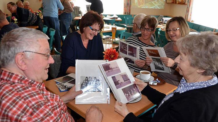 In alten Photoalben schmökern - ehemalige Sportler, Trainer und Kampfrichter des Turngaues Rhön/Saale kamen in Arnshausen zum "Generationentreffen" zusammen. Die Resonanzwar deutlich größer als bei den bisherigen reinen Seniorentreffen. Foto: Peter Rauch