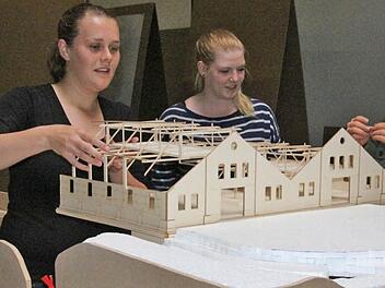 Anna-Maria Braun, Sarah Miller und Elisabeth Stölzl, Architekturstudentinnen im vierten Semester, setzen ihr Berghallen-Modell auf eine Landschaft aus Styropor. In ihrem Studienprojekt ging es um die mögliche Umnutzung der Berghallen auf dem Hofbräugelände. Foto: Simone Bastian