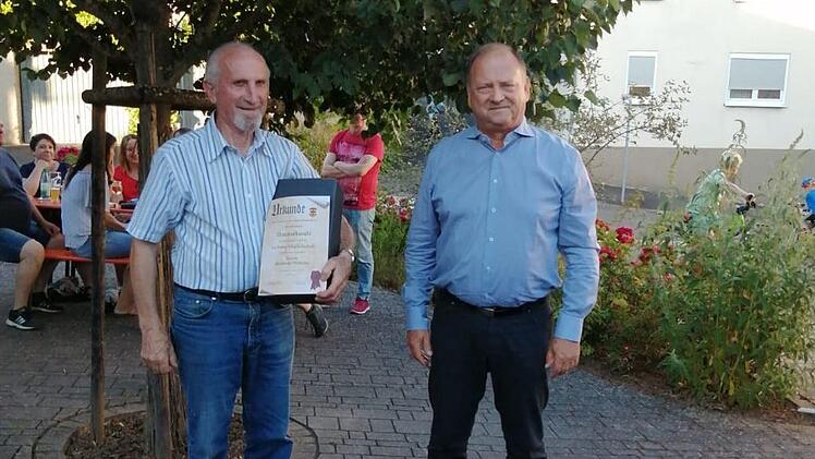 Unter der Linde wurde Reinhold Wilhelm (links) für seine langjährige Mitgliedschaft geehrt, rechts Gerald Meder.  Foto: Achim Meder
