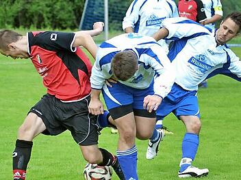 SCW Obermain II - FC Baiersdorf. Um den Ball stochern der Baiersdorfer Fabian Göhl (links) und die Weismainer Daniel Kremer und Michael Hagel (rechts).  Foto: Dieter Radziej